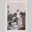 Woman sitting on a stone structure (ddr-manz-10-29)