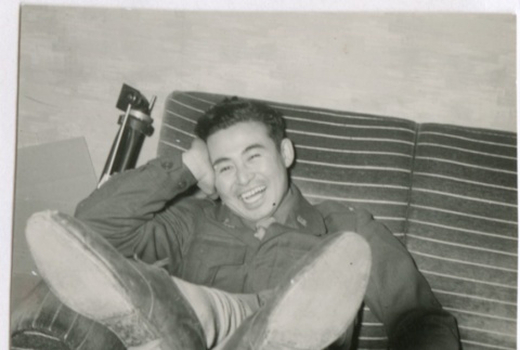 Ted Akimoto relaxing on a couch (ddr-densho-299-256)