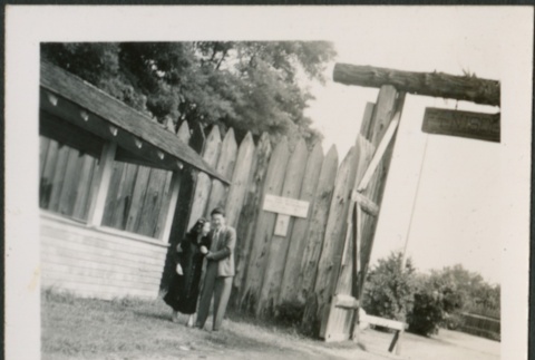 A couple standing in front of a fort gate (ddr-densho-298-269)