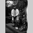 Girl in white sweater standing in garden (ddr-densho-426-2012)