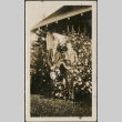Couple by flowers outside house (ddr-densho-316-169)