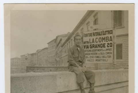 Soldiers sitting on wall next to city sidewalk (ddr-densho-368-93)