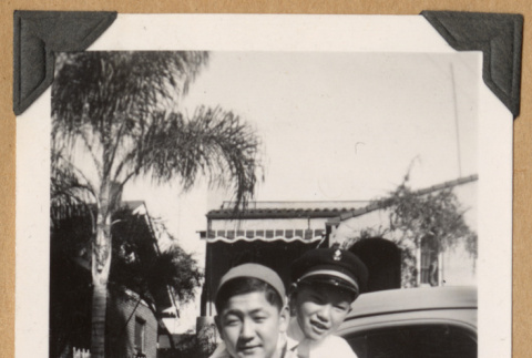 Two people pose by a car (ddr-densho-542-209)