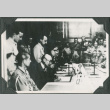 Men seated at table signing documents (ddr-ajah-2-717)