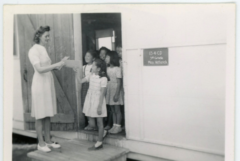 Miss Vetterick hands out final report cards (ddr-densho-37-2129)