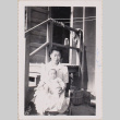 Woman holding baby outside barracks (ddr-densho-464-23)