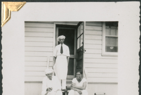 Three African American men on steps, Phil Jackson seated on left (ddr-densho-434-178)
