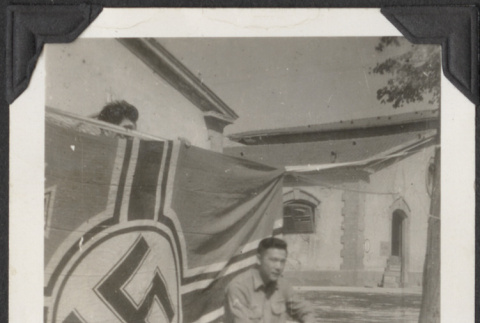 Man kneeling in front of Nazi flag (ddr-densho-466-666)