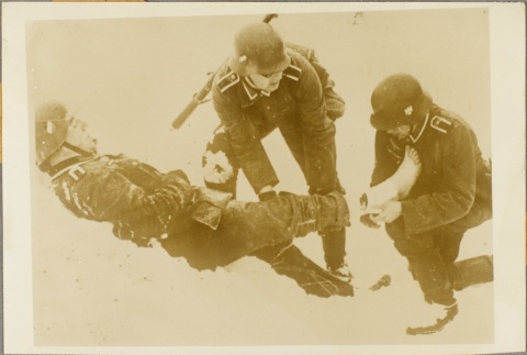 Two German medics bandaging a soldier's leg (ddr-njpa-13-882)