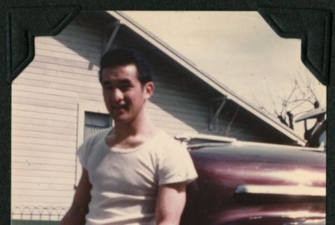 Walter Matsuoka sits on the bumper of a car (ddr-densho-390-83)