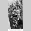 Girl holding doll in garden, wearing a kimono (ddr-ajah-6-367)