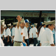 Veteran waving while marching in parade (ddr-densho-368-415)