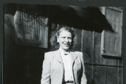 Photograph of Dr. Agnes V. Barlett standing in front of the Manzanar hospital (ddr-csujad-47-320)