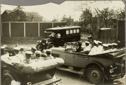 Naval officers in two cars watching a police van carrying 5.15 Incident defendants [?] (ddr-njpa-13-1371)