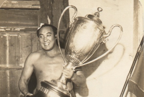 Sumo wrestler posing with trophy (ddr-njpa-4-2149)
