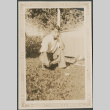 Man kneeling in grass (ddr-densho-316-298)