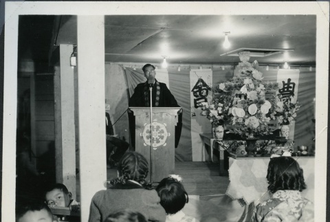 Rev. Shinjo Nagatomi speaking in the Manzanar Buddhist Church (ddr-manz-4-243)