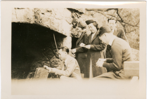 Two women and three men around outside fireplace (ddr-densho-426-1996)