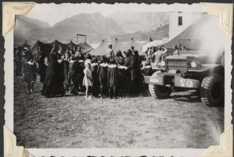 Group of children and nuns near tents with soldiers (ddr-densho-466-641)