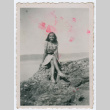 Young woman sitting on rock near water (ddr-densho-368-153)