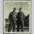 Two soldiers standing in front of tents (ddr-densho-201-381)