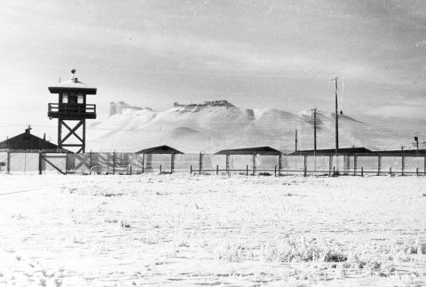 View of camp perimeter and guard tower (ddr-densho-37-237)