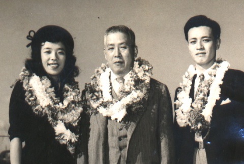 Utashito Nakashima, his daughter and a koto player posing with leis (ddr-njpa-4-1319)