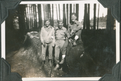 Three men sitting on a log (ddr-ajah-2-249)