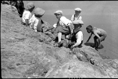 Some boys sit at the edge of a stony cliff (ddr-densho-480-20)