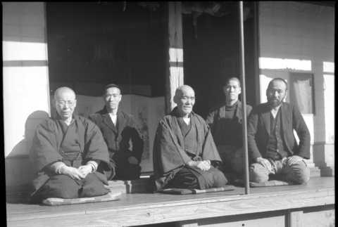 Group of men seated outside house (ddr-densho-426-307)