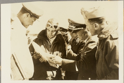 Pilots and military officers looking at a document (ddr-njpa-13-836)