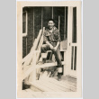 Man sitting on porch railing (ddr-densho-368-525)