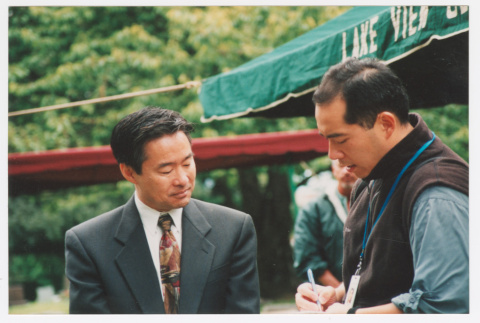 Tom Ikeda speaking to journalist (ddr-densho-506-32)