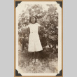 Girl poses by a bush (ddr-densho-542-180)