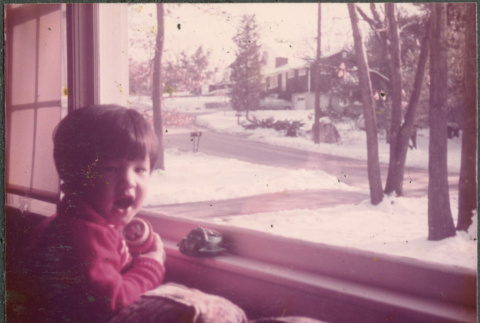 Boy looking out window at snow (ddr-densho-523-555)