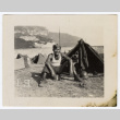 Soldier sits besides a tent (ddr-densho-451-11)