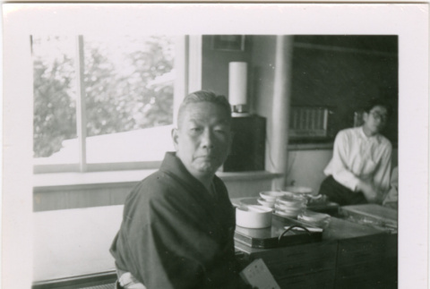 Man seated by low tables (ddr-densho-426-2460)