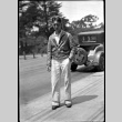 Man in leather jacket and sunglasses standing by car (ddr-densho-426-1832)