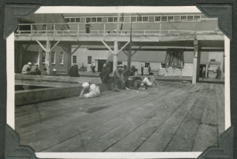 Men relaxing around pier (ddr-densho-540-42)