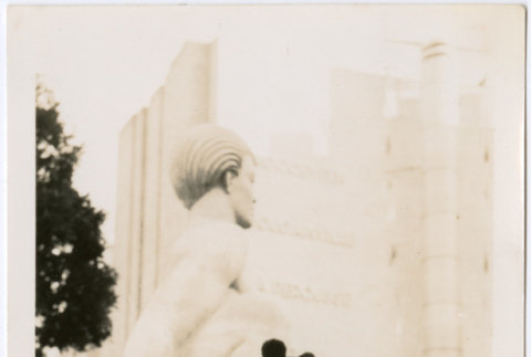 Tomoye Nozawa standing in front of stone statue (ddr-densho-423-472)