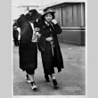 Pair walking in dark coats (ddr-densho-1007-56)