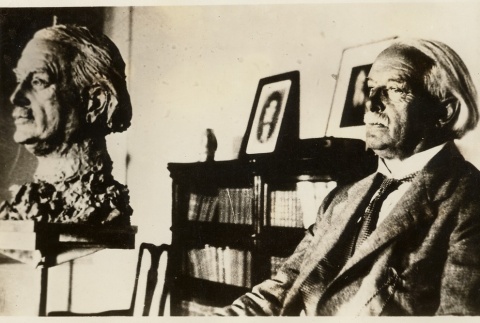 David Lloyd George sitting next to a sculpture of his likeness (ddr-njpa-1-1204)