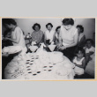 Woman cutting a cake at a party with women and children (ddr-densho-522-27)