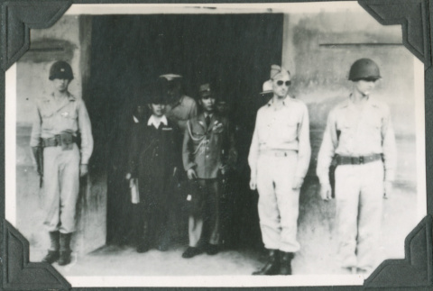 Men standing in doorway with guards on either side (ddr-ajah-2-716)