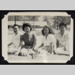 Four people seated on grass (ddr-densho-542-709)