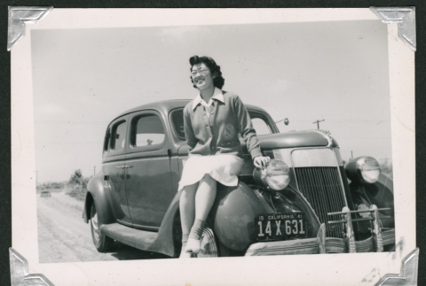 Tsuruko Mizusawa sitting on car (ddr-densho-550-137)