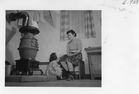 Hiroko Nishi reading to her daughter in their barracks apartment (ddr-fom-1-862)