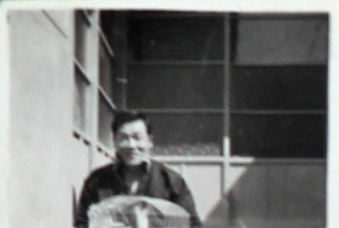 Man holding a birdcage (ddr-densho-252-65)