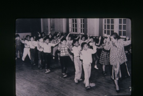 (Slide) - Image of woman leading children in a dance (ddr-densho-330-129-master-1a7a4b9bf4)