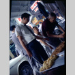Two men and a boy at street market stall (ddr-densho-426-739)